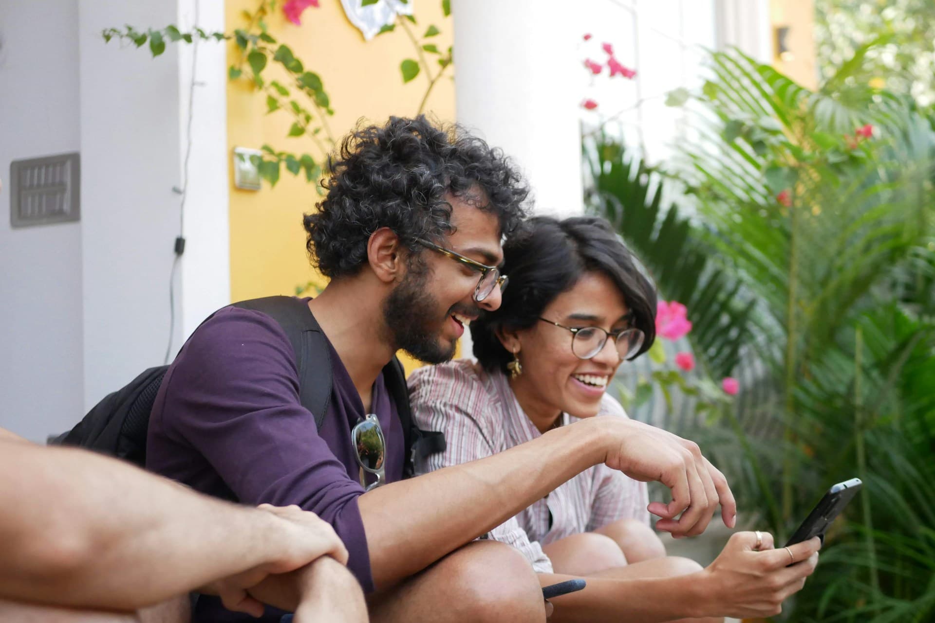 Two people laughing at something on a phone screen